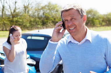  Mand and woman making a phone call after car accident